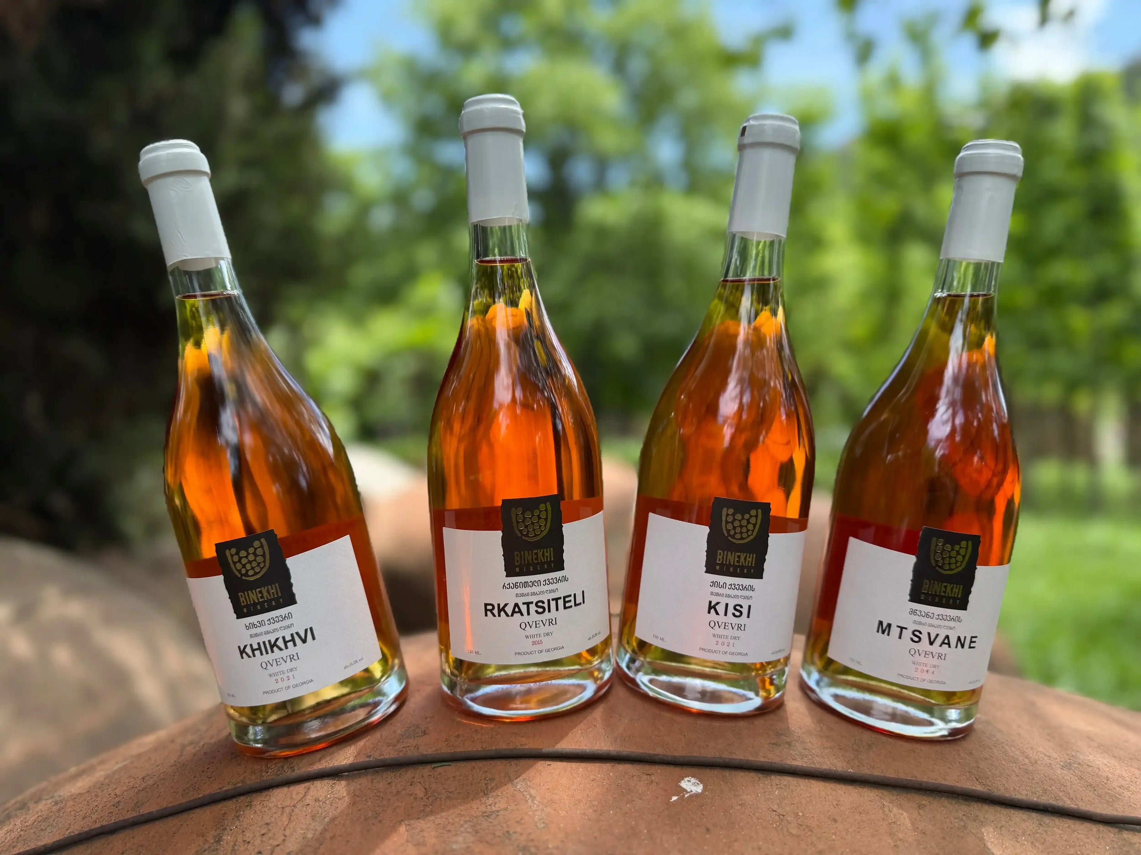 クヴェヴリの上に並べられたBinekhiワイナリーのオレンジワイン4種