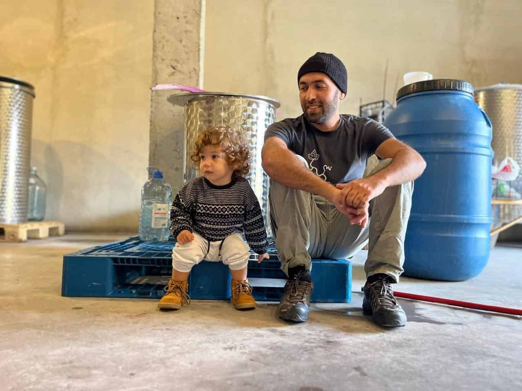 ラチャ地方のMenabdeワイナリーのオーナーが、子供と一緒にセラーで休憩中