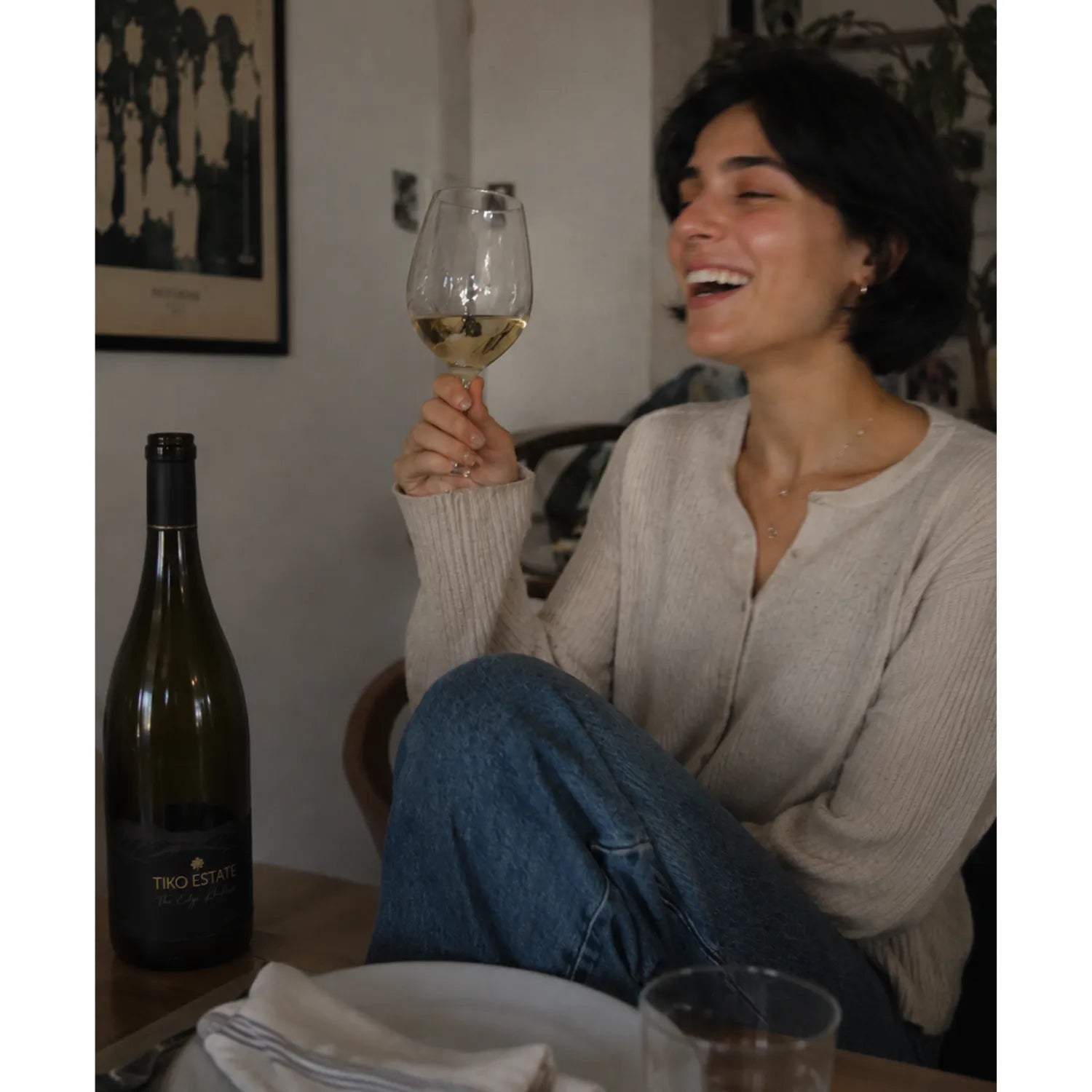ティコ・エステートのジョージアワインを手に食卓で笑う女性を写したライフスタイル画像