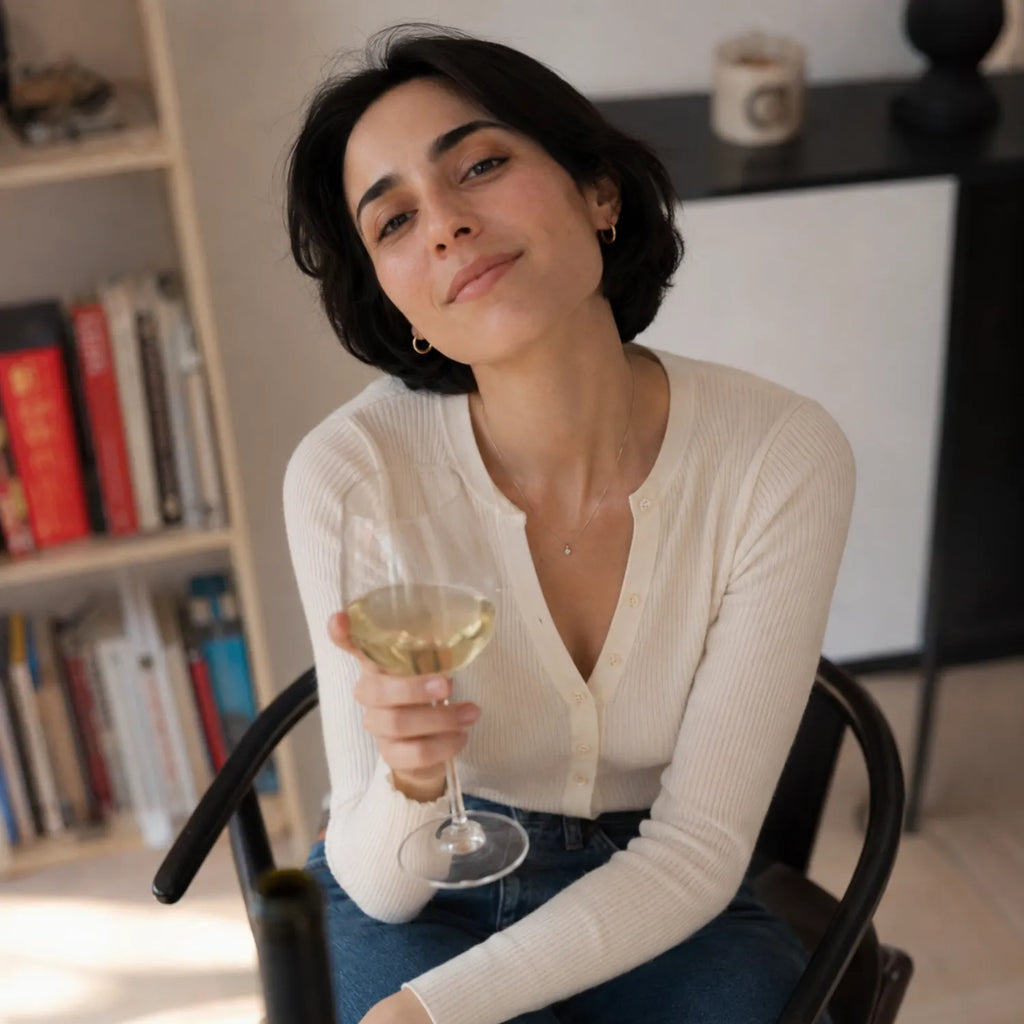 ティコ・エステートのジョージアワインのグラスを手に椅子でくつろぐ女性のポートレート画像