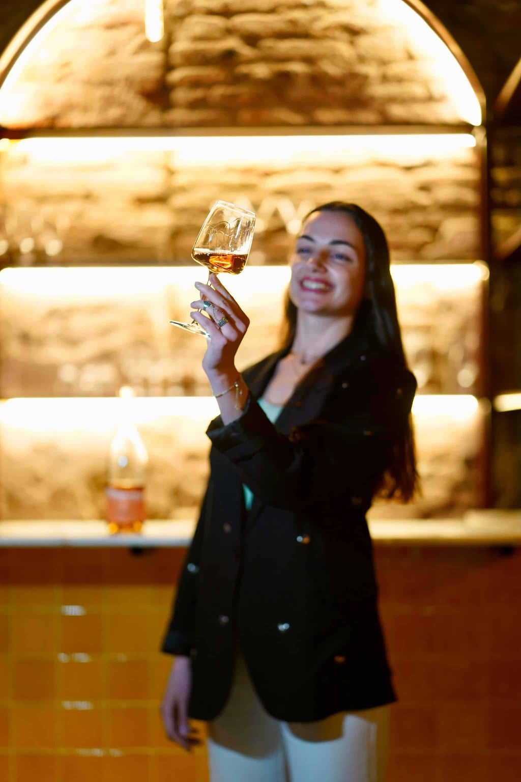 地下貯蔵庫でティコエステイトのオレンジワインを飲む女性